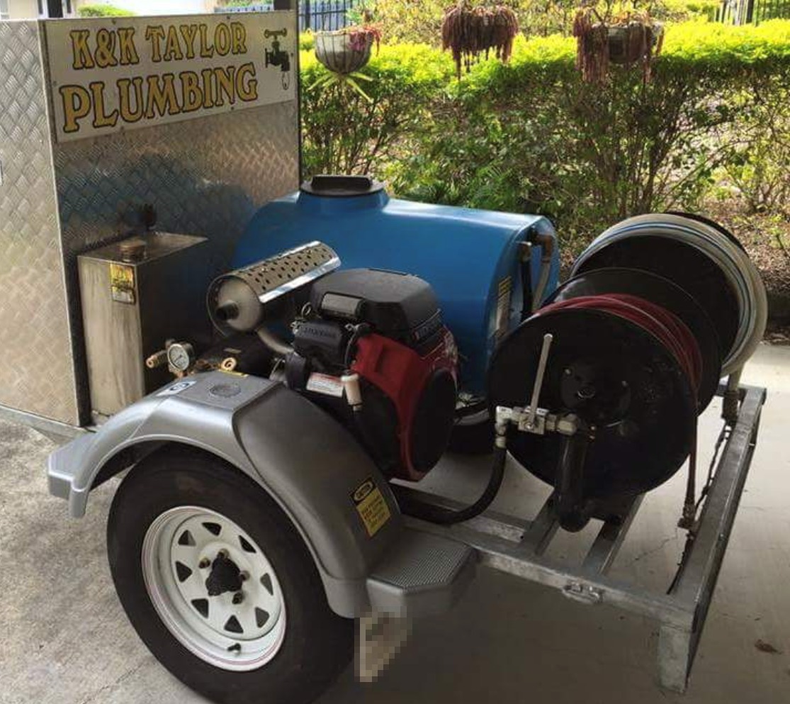 The K&K Taylor Plumbing drain jetter trailer: gold sign-written board, blue water tank, engine and hose reels